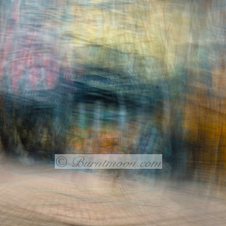 A blurred, abstract street scene in Amsterdam with soft, swirling motion and hints of architectural elements, created using intentional camera movement (ICM).