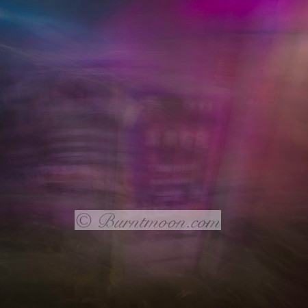 A blurred, abstract night scene with neon purples and blues, created using intentional camera movement (ICM), evoking the mood of a city at night.